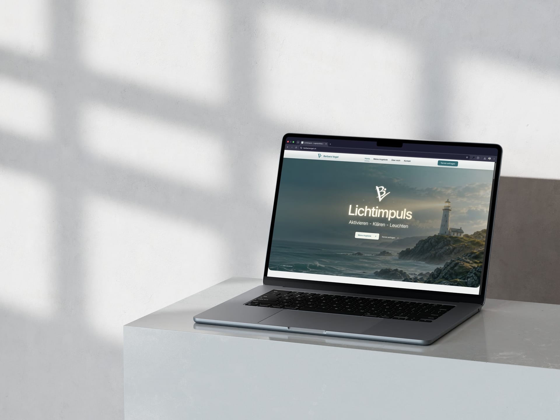 MacBook auf einem weissen Marmorblock mit Fensterschatten: Startseite der Website Lichtimpuls von Barbara Vogel mit animiertem Hero, Leuchtturm und den Buttons «Meine Angebote» und «Termin anfragen».