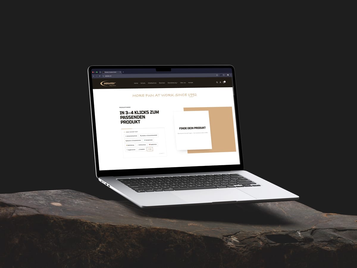 MacBook Air frontal auf Fels: der Produktfinder des Wekatex-Webshops – «In 3–4 Klicks zum passenden Produkt» mit Auswahl nach Sicherheitsschuhen, Bekleidung, Handschuhen und weiterem Arbeitsschutz.