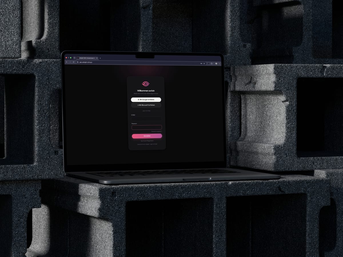 MacBook auf einem Betonblock, auf dem Bildschirm die Anmeldung von adsight GEO im Dunkelmodus mit Login über Google, Microsoft oder E-Mail.